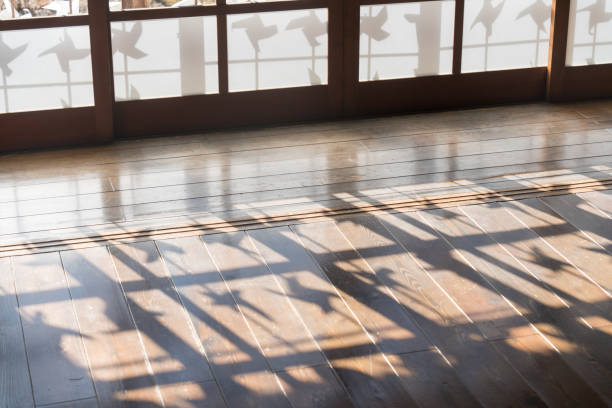 The shadow of a windmill reflected in the wooden floor