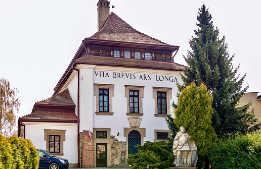 Gorlica, Poland - May 2, 2022: View of the building of the city museum and the monument to the founder of the city. The text on the building translates from Latin: \
