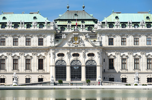 The King is in, the Royal's flag is flying over their mansion. Two Guards are visible in their guard kiosks, there are many more around the building, the grounds of which are open to the general public.