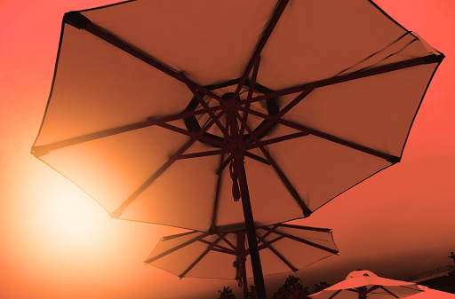 Beach umbrella on sunset sky,  looking up