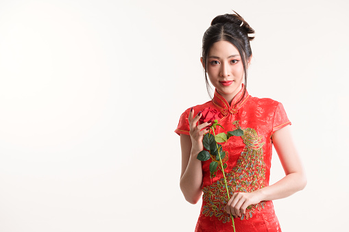 Beautiful young Asian woman wear cheongsam and smile to you in Chinese new year