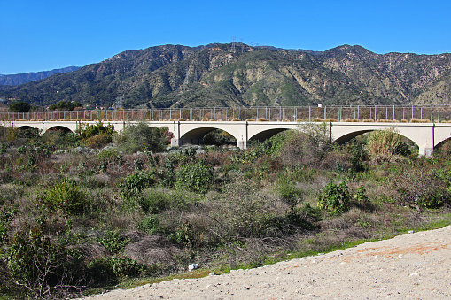 Now a footpath and once a railroad bridge is the Puente Largo Bridge over the San Gabriel Riverbed in Azusa, California, with Mount Bliss in background.