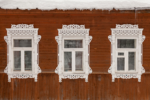 Three antique windows with carved white frames.