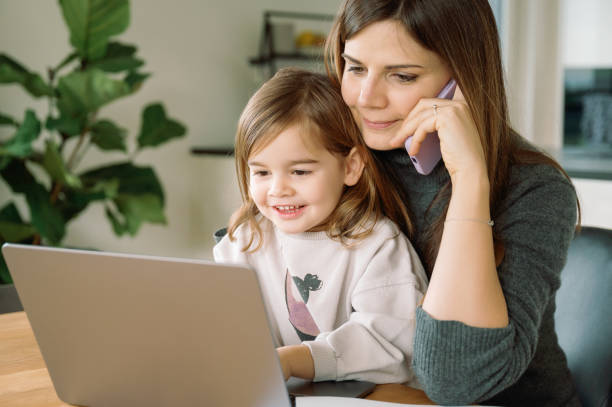 istock Smiling Child with Remote Working Mother on Phone 2014418923