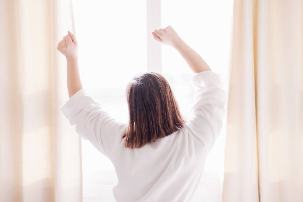 istock Woman stretching in morning and open curtains, early wake up concept. 2014447607