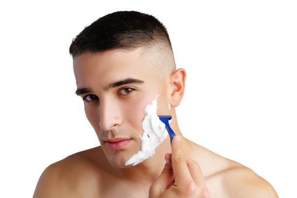 istock Young handsome man applying shaving foam against white background 2014455531