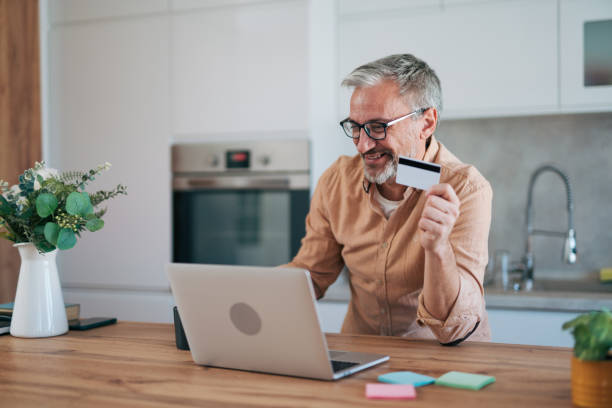istock mature man uses a credit card for online shopping. 2014502682
