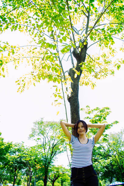 Beautiful young woman sitting close to a  tree and thinking on something