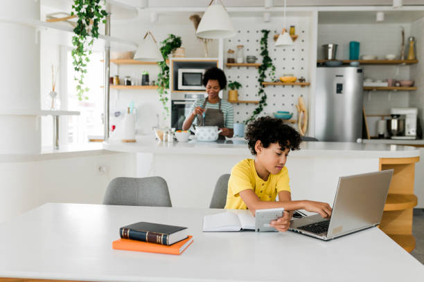 istock Boy doing homework while his mother cooking in the background 2014608452