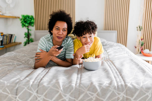 istock Mother and son watching TV and lying on bed 2014611117