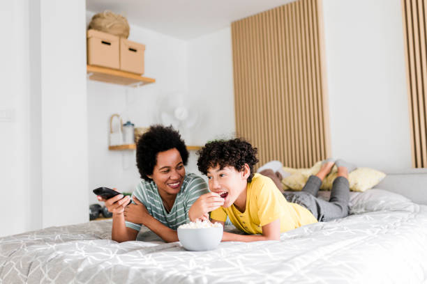 istock Mother and son watching TV and lying on bed 2014614230