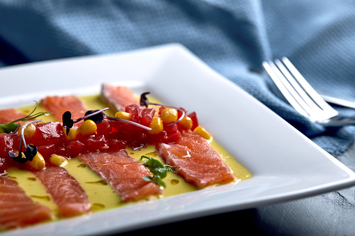 Slice of salmon with pepper, seasalt, herbs and olive oil. Top view, space for text