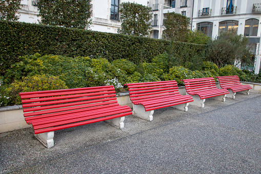 city street with comfortable four red wooden benches