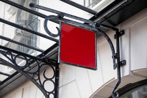 Blank red sign panel outside on facade shop or restaurant with empty copy space for store text mockup