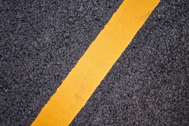 istock New asphalt road surface with yellow line background 2014666059