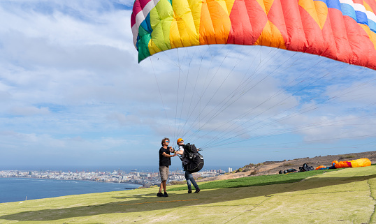 Beginner paraglider learning how to paraglide with a teacher