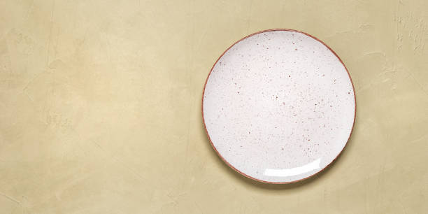 istock Empty white plate on a beige plaster background. Top view, flat lay, copy space. Banner 2014668269