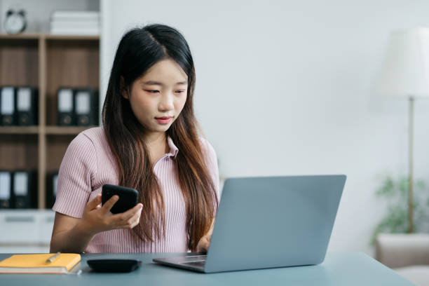 istock Women work on laptop on the table at the office with information documents. 2014701860