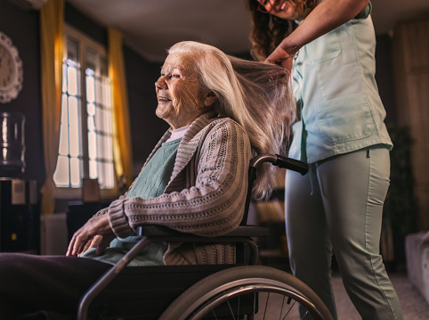 nurse in a home visit to an elderly woman with disabilities