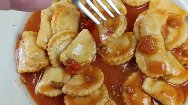 close up of a person eating ravioli