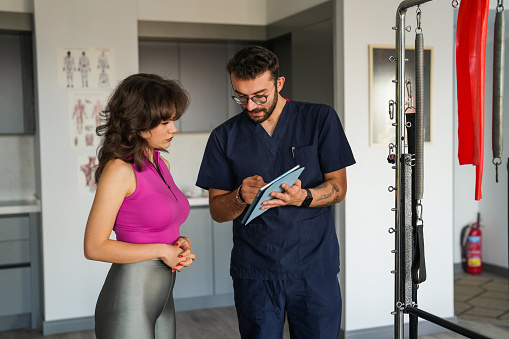 Physiotherapist giving information to young woman