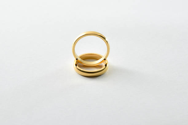 istock Engagement gold ring standing on each other isolated white 2014725704