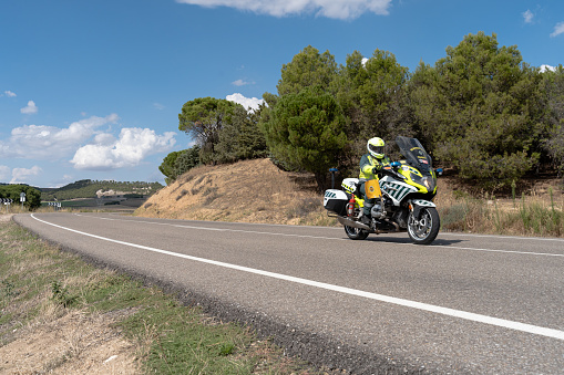 Tordesillas, Valladolid-Spain, September 15, 2023; Guardia Civil agent in Spain on a motorcycle, on a secondary road in a rural area, the motorcyclist is covering the security of a cycling race, it is the \
