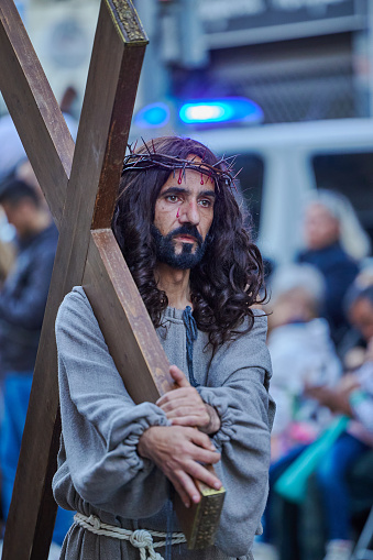 Valencia, Spain - April 7, 2023: Unidentified actor in historical costume, Jesus with the cross on procession of Holy Week on the street.