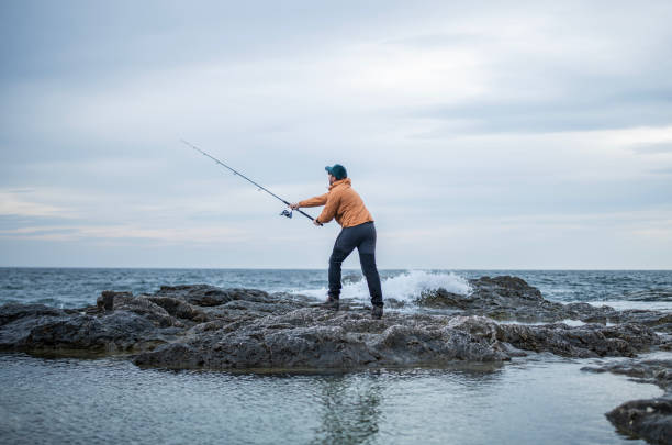 istock Fisherman casting at a shore fishing. 2014753817