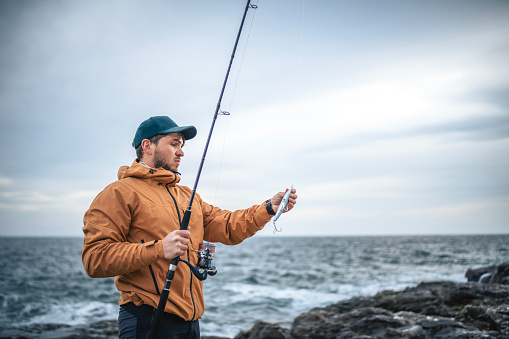 Hobbie fisherman preparing his gear for a shore fishing at the sea.