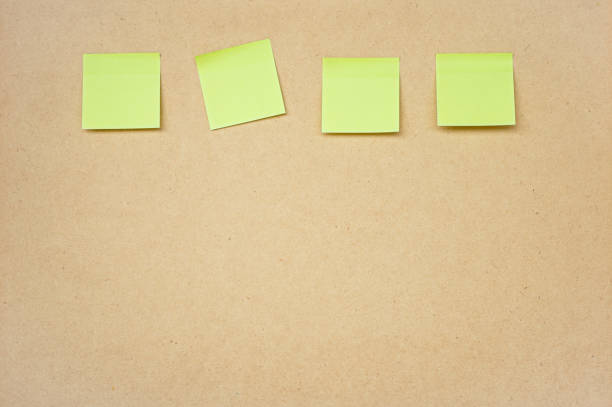istock Four yellow sticky note on brown clipboard or plywood board background 2014786260