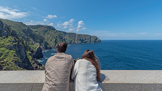 Estaca de Bares, La Coruña, Spain - 08/18/2021: Boy and girl at the viewpoint looking at the maritime landscape
​