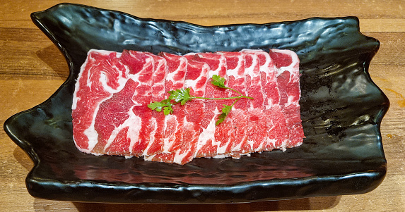 Fresh raw beef ribs meat on black plate