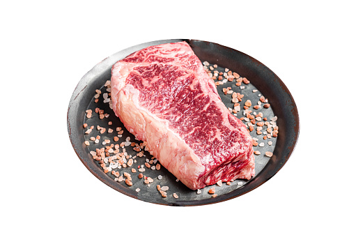 Fresh Raw Wagyu striploin or New york steak in a steel tray with herbs.  Isolated on white background.  Top view