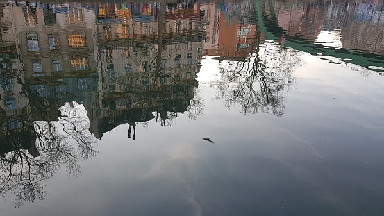 A building reflecting in the water of Canal St.Martin in Paris.