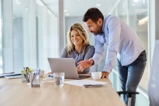 istock Happy business colleagues working on laptop in the office. 2014887783
