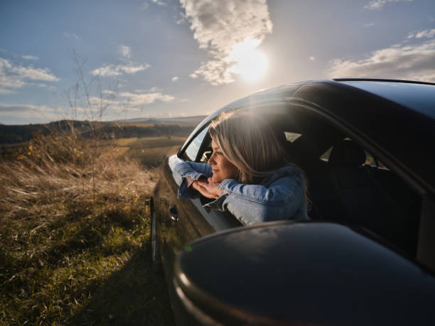 istock Smiling woman day dreaming while relaxing in a car. 2014923769