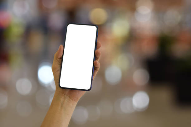istock Hand holding smartphone with blank screen on bokeh light background 2014933689