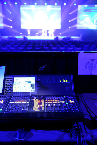 Backstage area in a conference hall with technical staff handling light and sound