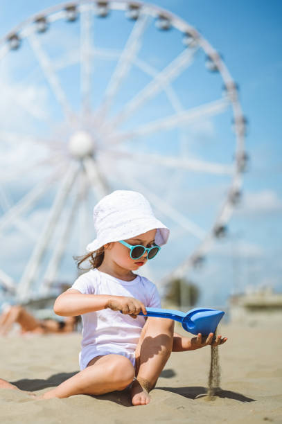 Little girl playing with sand on a beach.