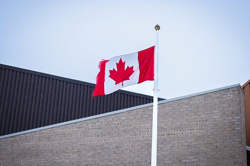 Ottawa, Canada - Canadian flag in wind in front of a house