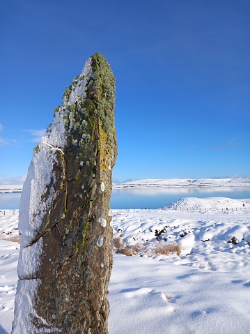 A standing stone from the Ring of Brodgar in the snow in the heart of Neolithic Orkney.