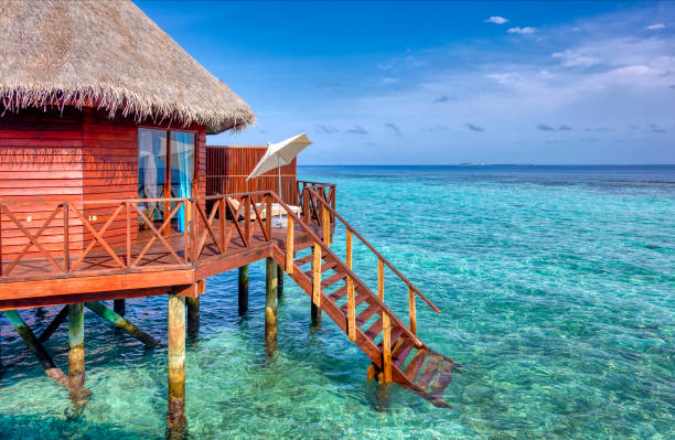 Over water bungalow on stilts in blue ocean
