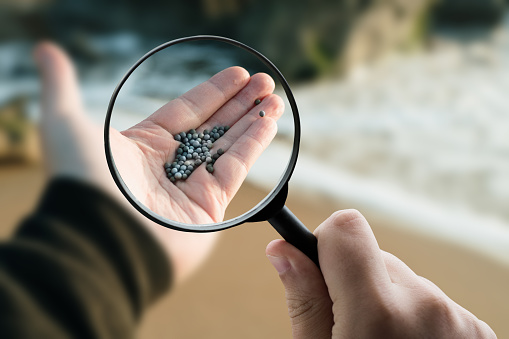 A magnifying glass focusing on microplastics