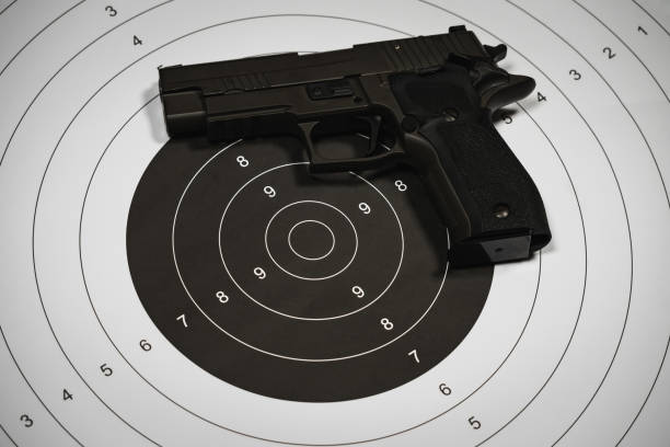 istock Classic shooting target and 9-mi pistol, close-up photo. 2015003592