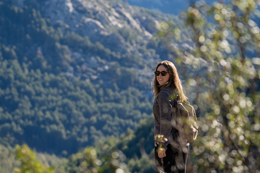 A blonde girl with sunglasses treks along mountain trails, embodying the spirit of adventure and exploration in the great outdoors.