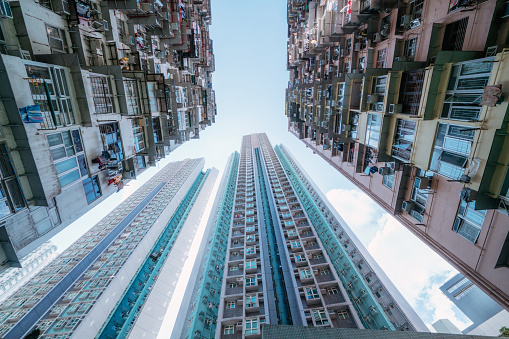 Upward view of towering skyscrapers against the sky in a dense urban setting.\nHongkong, China