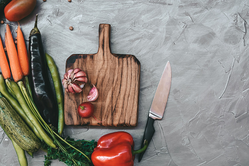 Food composition with ripe vegetables and kitchen knife.