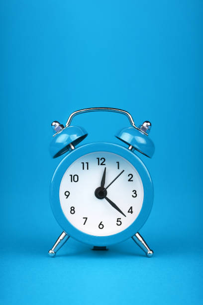 istock Close up one blue alarm clock over blue background 2015036629