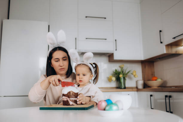 istock excited mother and child looking at easter bread near easter eggs, decorative rabbits and tulips 2015043196